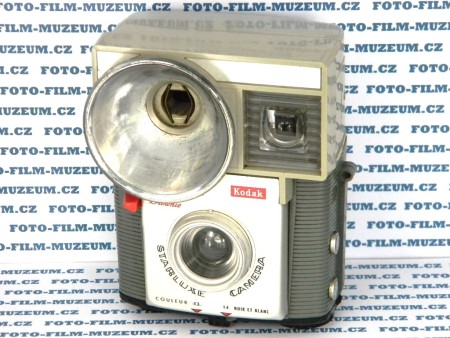 Fotoaparát Kodak Starluxe. Typ box, na svitkový film. S jednoduchým optickým průhledovým hledáčkem a vestavěným bleskem na jednorázové bleskové žárovky. Materiál plast. 