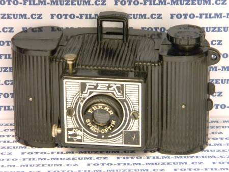 Fex v provedení No1. Pravý čtverec je černý bez uvedení země výroby. Výroba cca od r.1938. Tělo z lisovaného bakelitu. Čas T + M-cca 1/25s. Hledáček rámový. Bylo možné dokoupit hledáček optický průhledový. Na svitkový film 127. Formát negativu 4x6,5cm.