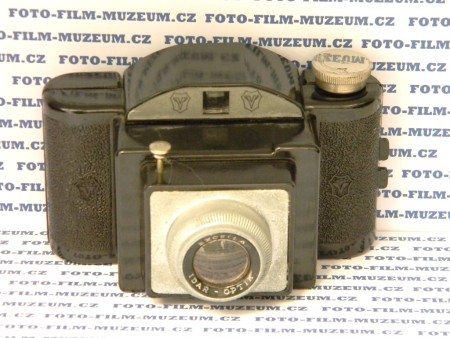 Jednoduchý bakelitový přístroj na svitkový film 127. Formát negativu 6,5x4cm. Výroba asi od r. 1944. Přetáčení knoflíkem, kontrola čísla snímku na zadní straně přes červené okénko. 1 čas(cca 1/25s.) + B.